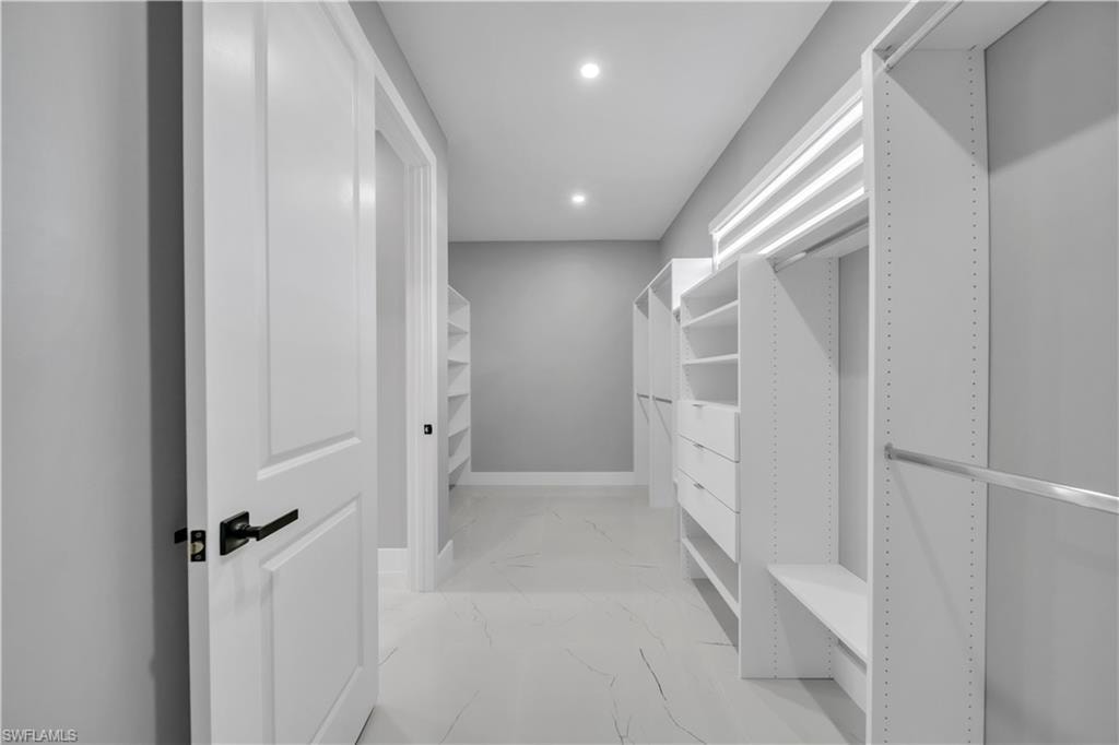 Spacious closet with light marble finish floors