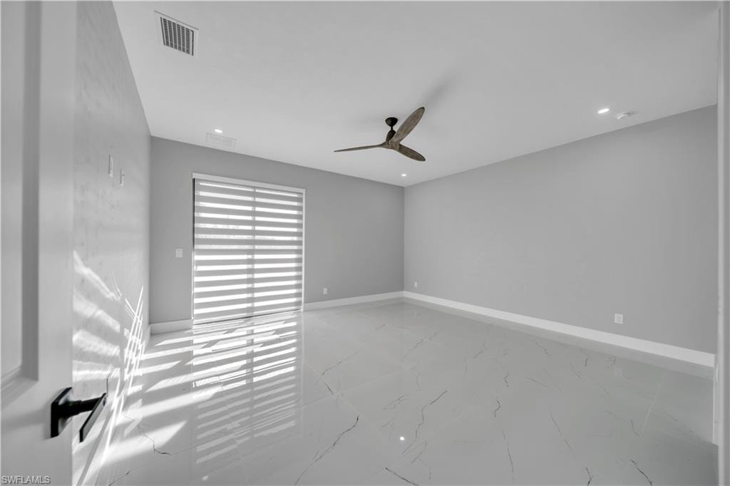 Spare room featuring light marble finish floors, a ceiling fan, and recessed lighting