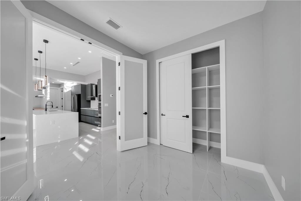 Unfurnished bedroom with light marble finish floors, a closet, and recessed lighting