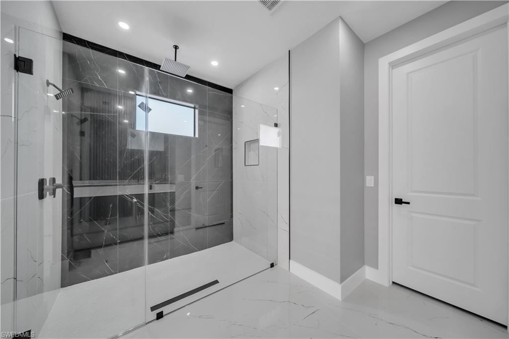Full bath featuring marble finish floors, a marble finish shower, and recessed lighting