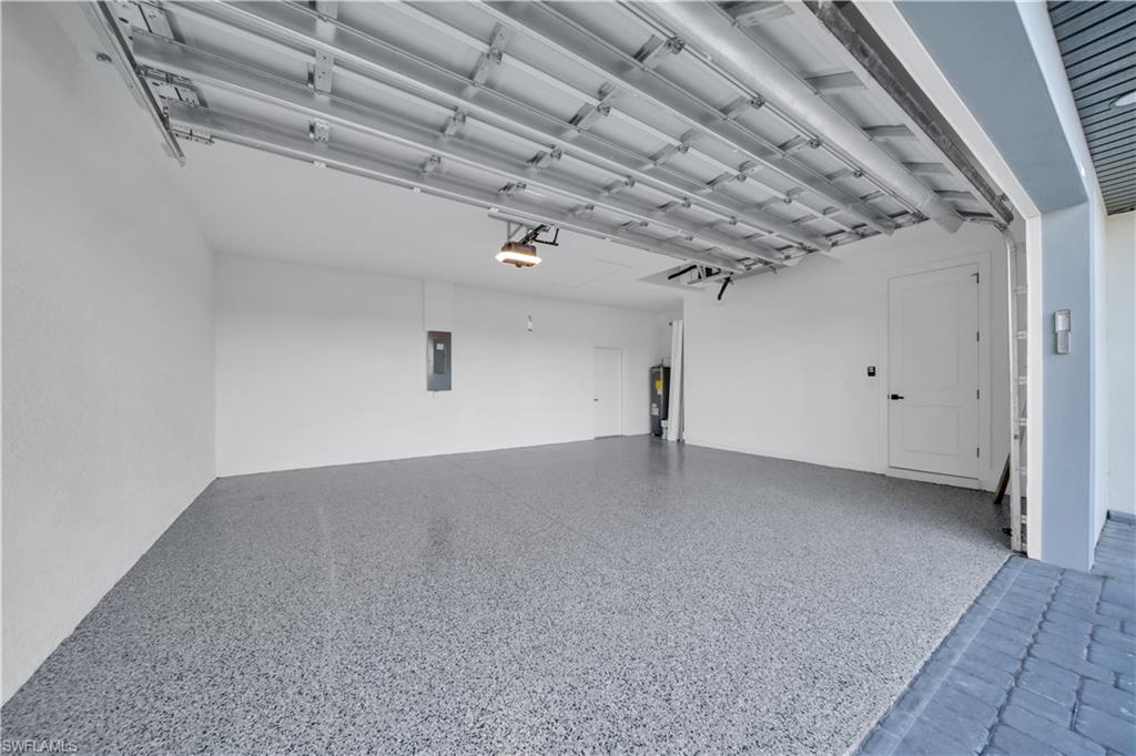Garage featuring electric panel and water heater