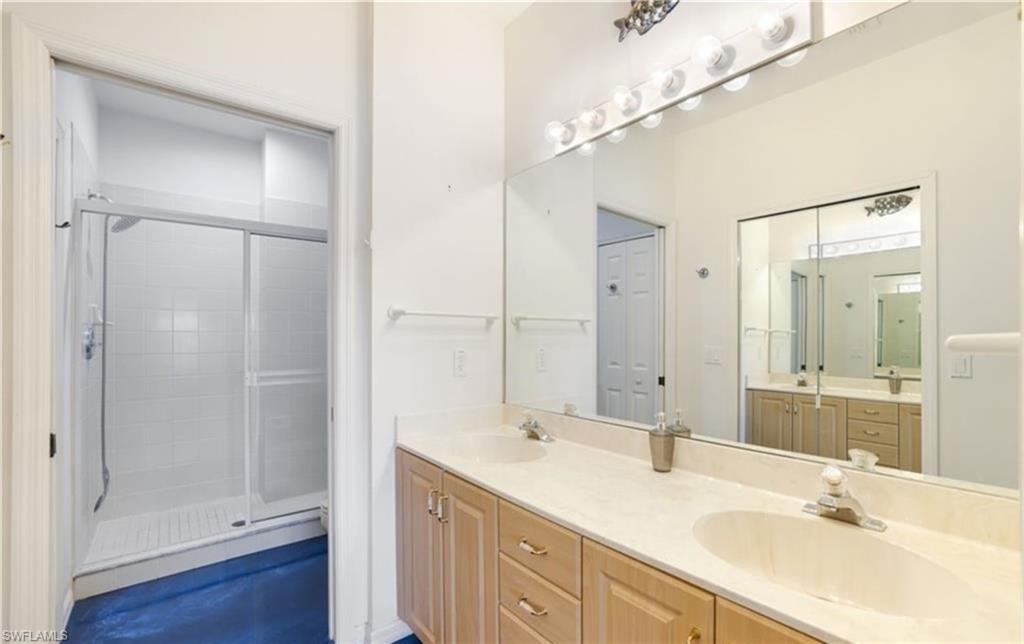 Full bathroom with double vanity and a shower stall