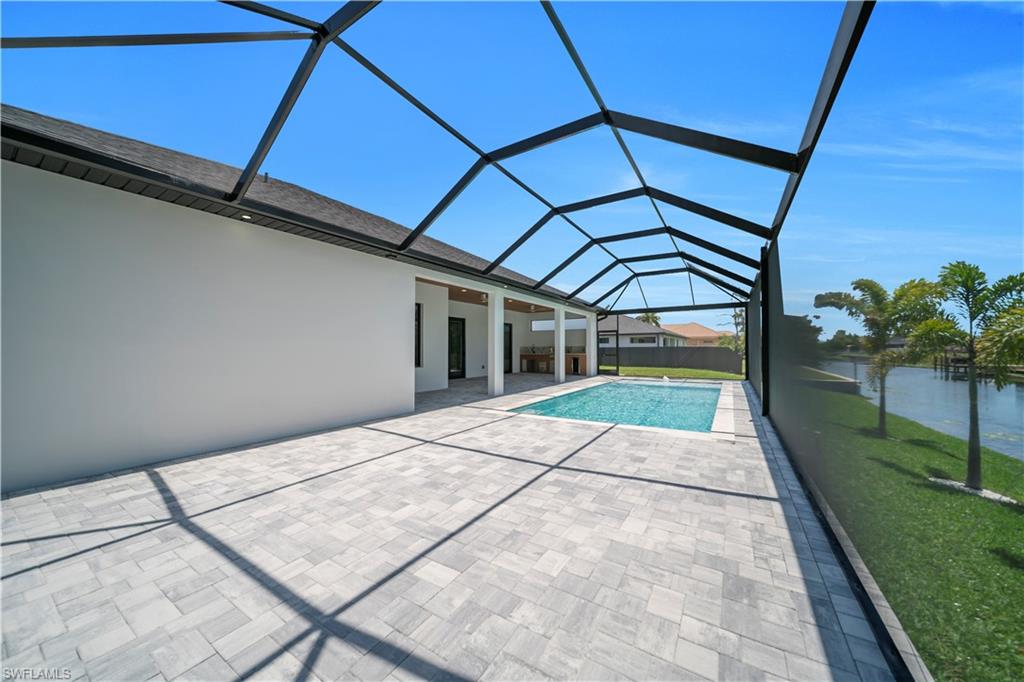 Expansive screened patio featuring a rectangular swimming pool and light-toned paver decking