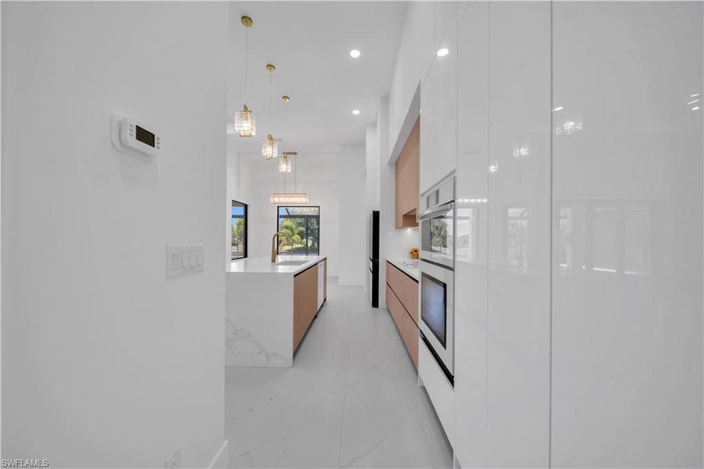 Contemporary kitchen featuring white high-gloss cabinetry and integrated appliances