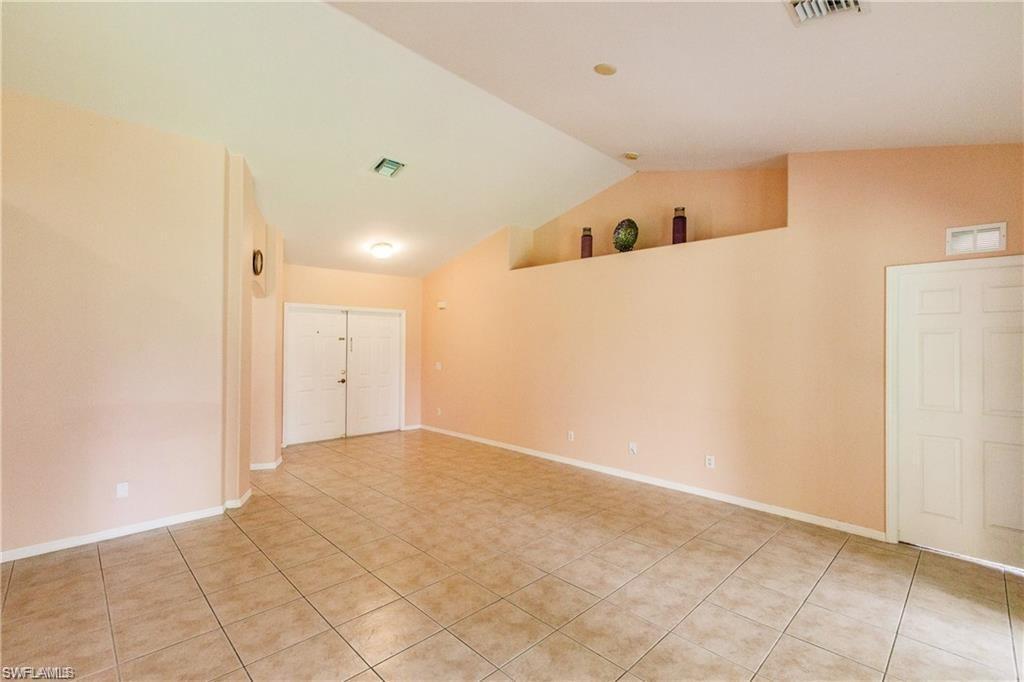 Spare room with vaulted ceiling and light tile patterned flooring
