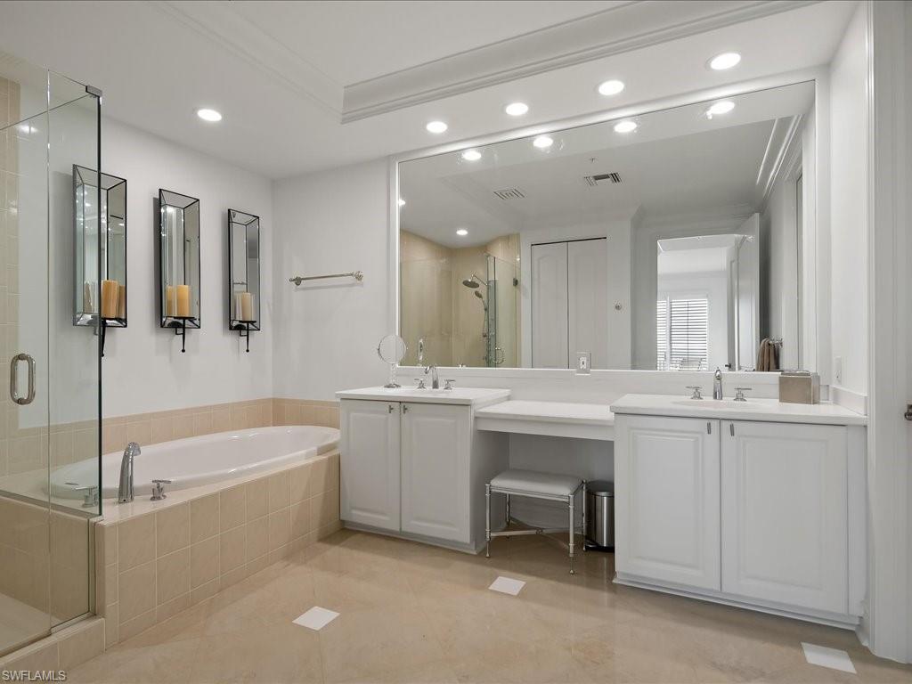 Bathroom with a stall shower, double vanity, a garden tub, recessed lighting, and crown molding