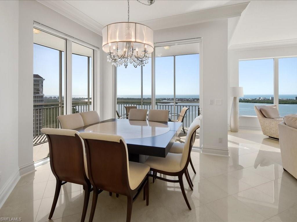 Dining space featuring a water view, ornamental molding, and a chandelier