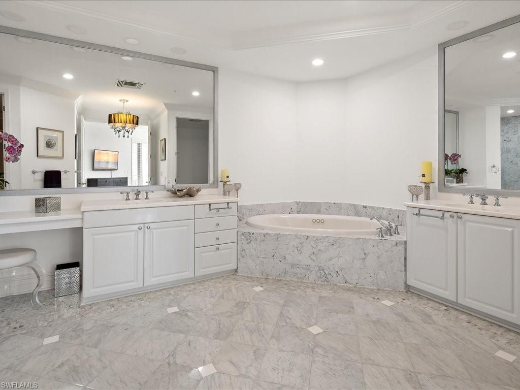 Full bath with two vanities, a garden tub, and recessed lighting