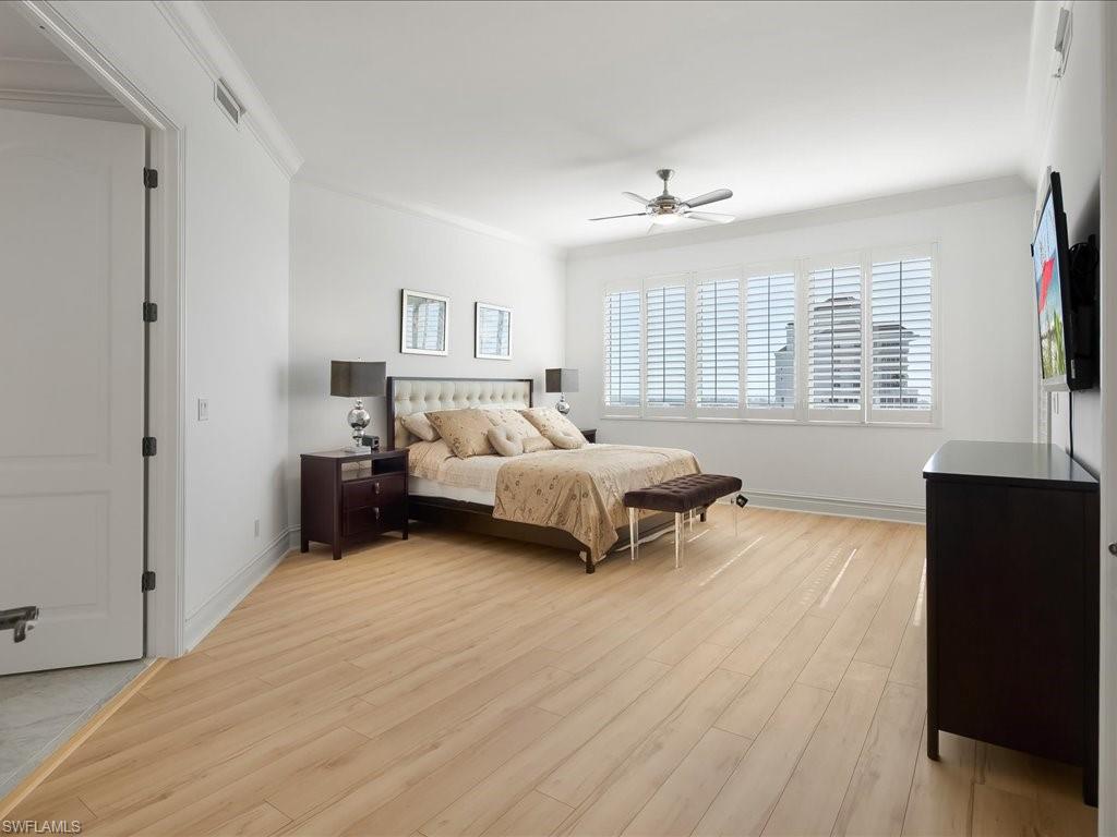 Bedroom featuring crown molding, light wood finished floors, and a ceiling fan