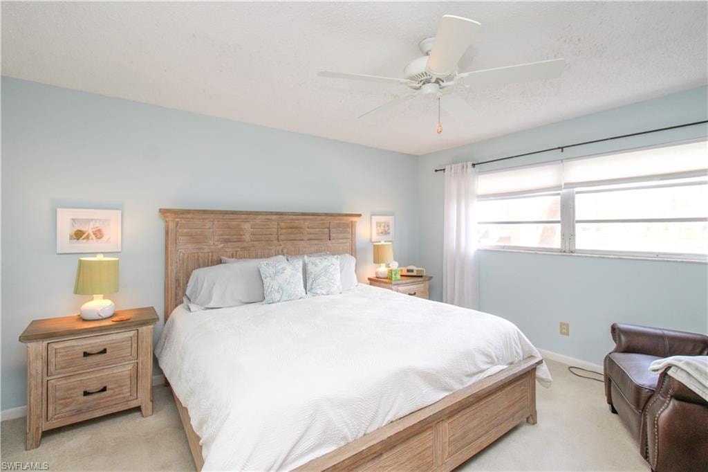 Bedroom with ceiling fan and light colored carpet
