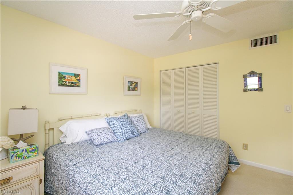 Carpeted bedroom featuring a closet and ceiling fan