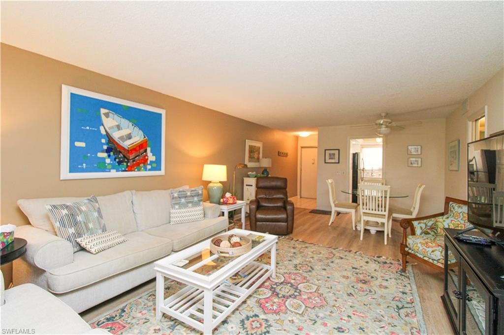 Living room with ceiling fan and light hardwood / wood-style floors