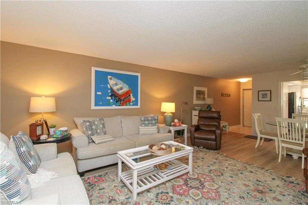Living room with a textured ceiling and wood-type flooring