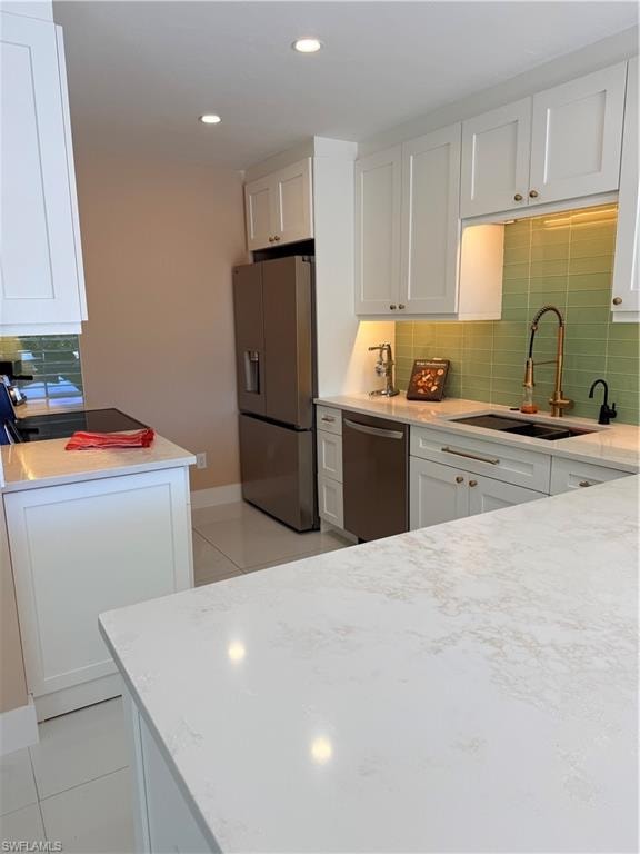 Kitchen with decorative backsplash, white cabinetry, new appliances, light tile floors, and recessed lighting and beautiful gold pot filler
