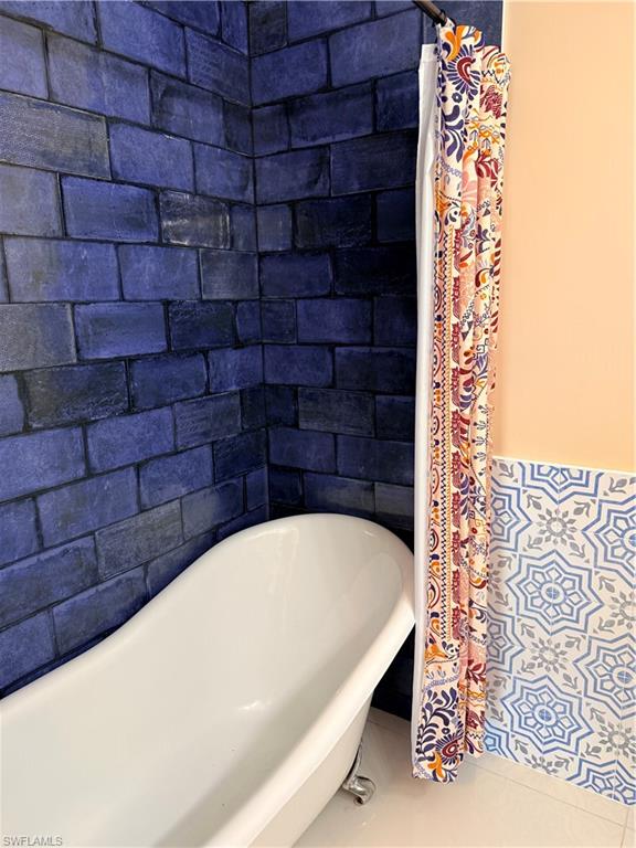 Bathroom with a soaking tub and curtained  shower