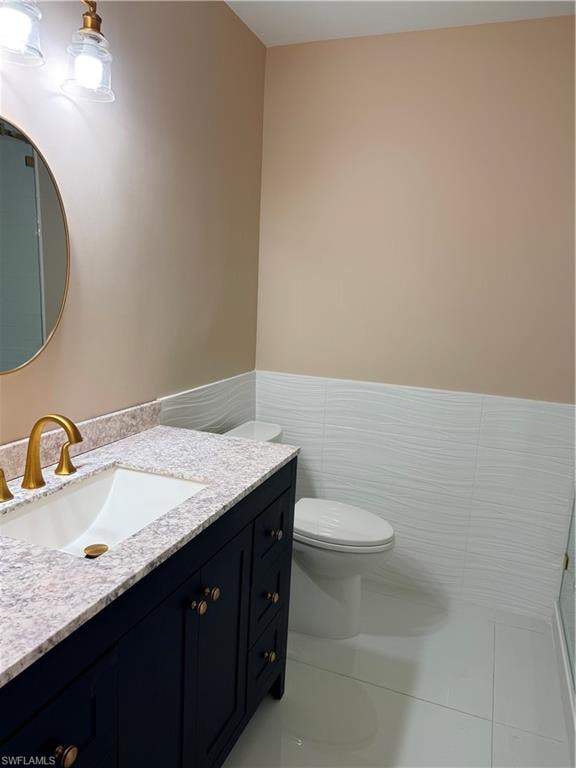 Guest Bathroom with vanity, tile walls, light tile patterned flooring, and wainscoting