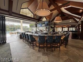 Bar area featuring high vaulted ceiling