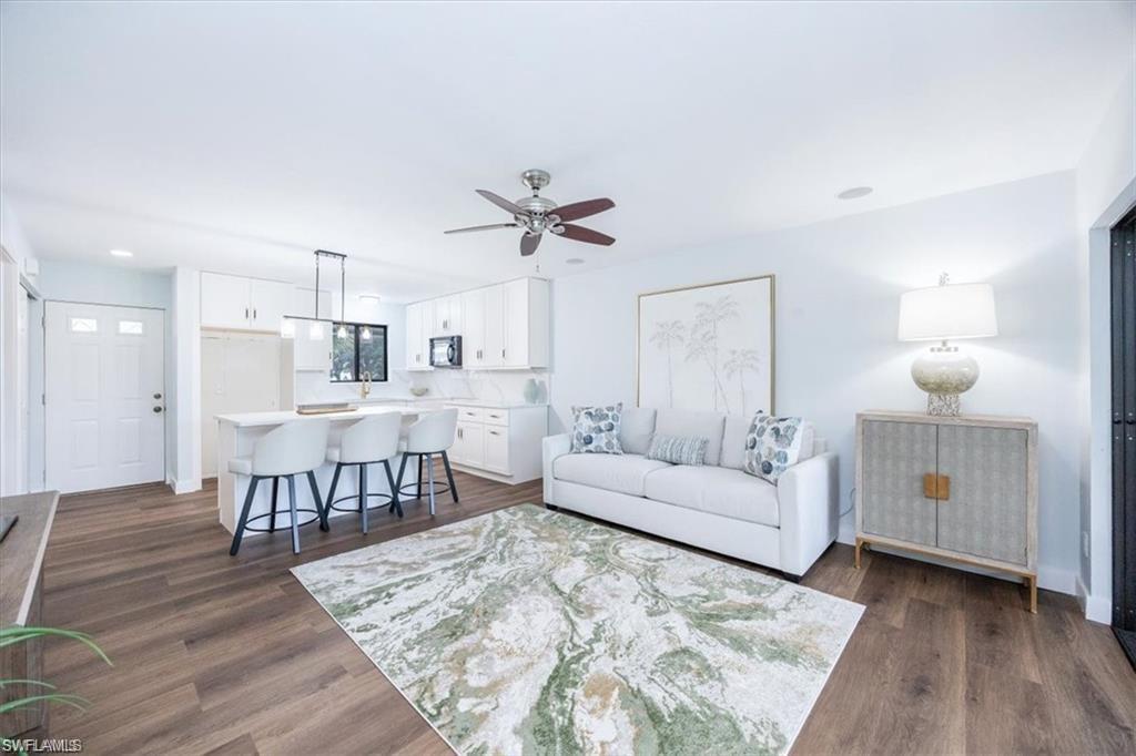 Living room featuring dark wood-style floors, a ceiling fan, and recessed lighting