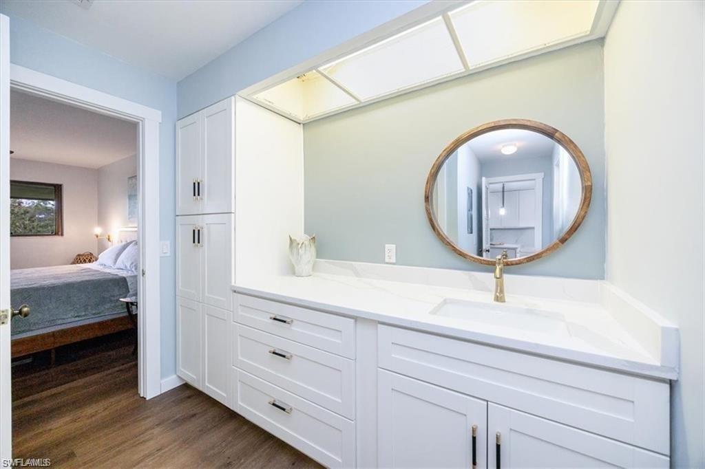Ensuite bathroom featuring vanity and dark wood-style flooring