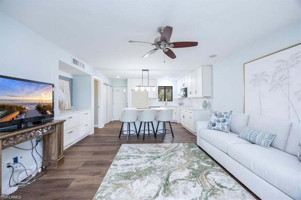 Living area with dark wood-style flooring and ceiling fan