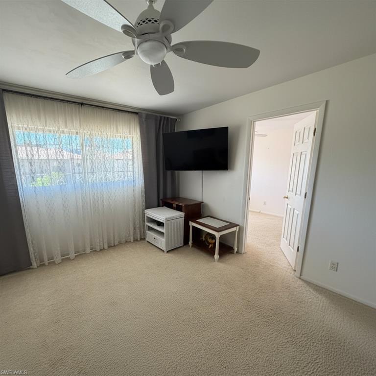 Living room with balcony access and entry to the primary bedroom