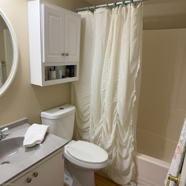Primary bathroom: Full bath with shower / tub combo with curtain and vanity