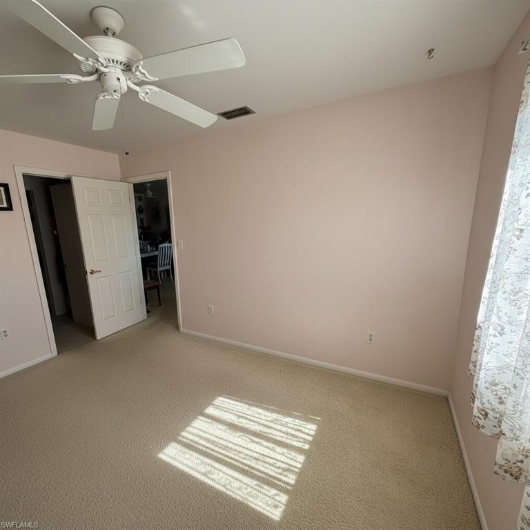 Primary bedroom with walk-in closet and ceiling fan