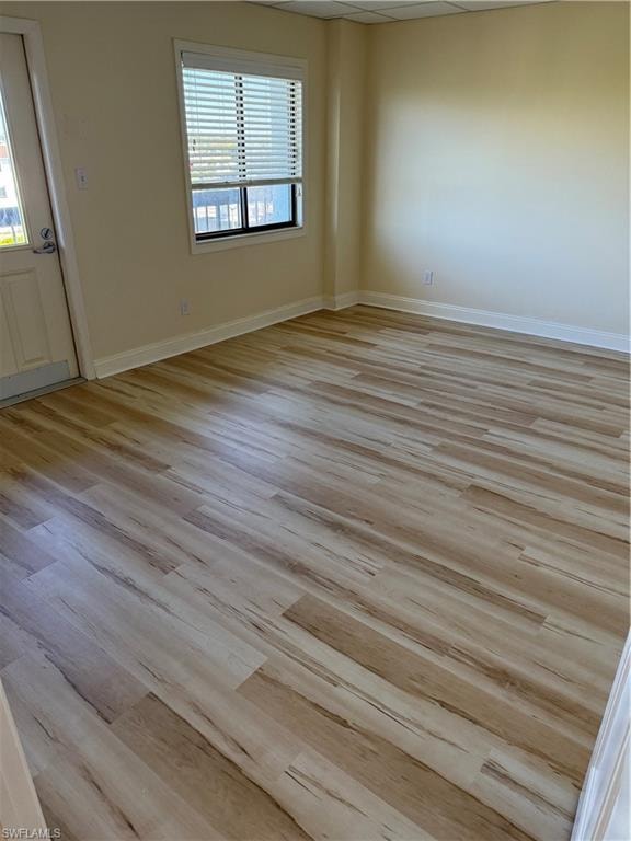 Spare room with baseboards and light wood-style floors