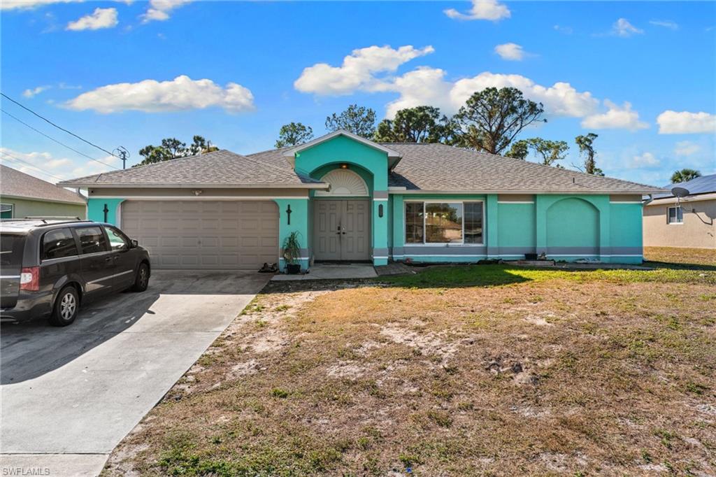 Ranch-style home featuring concrete driveway, a shingled roof, an attached garage, and a front lawn