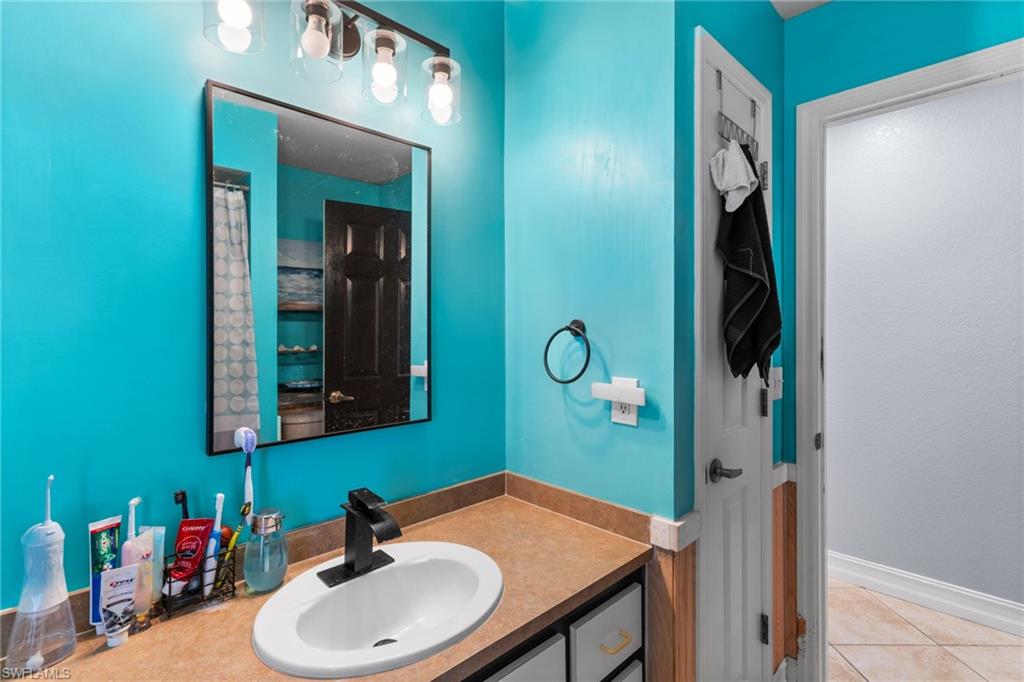 Bathroom featuring vanity, a shower, and light tile patterned floors
