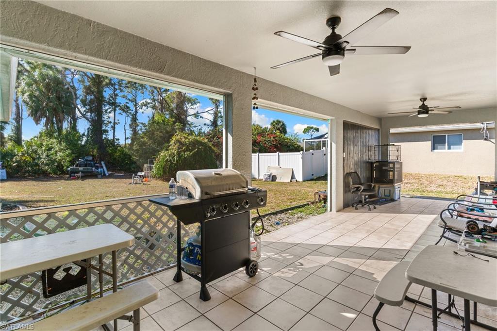 Fenced backyard with grilling area, a patio area, ceiling fan, and outdoor dining space