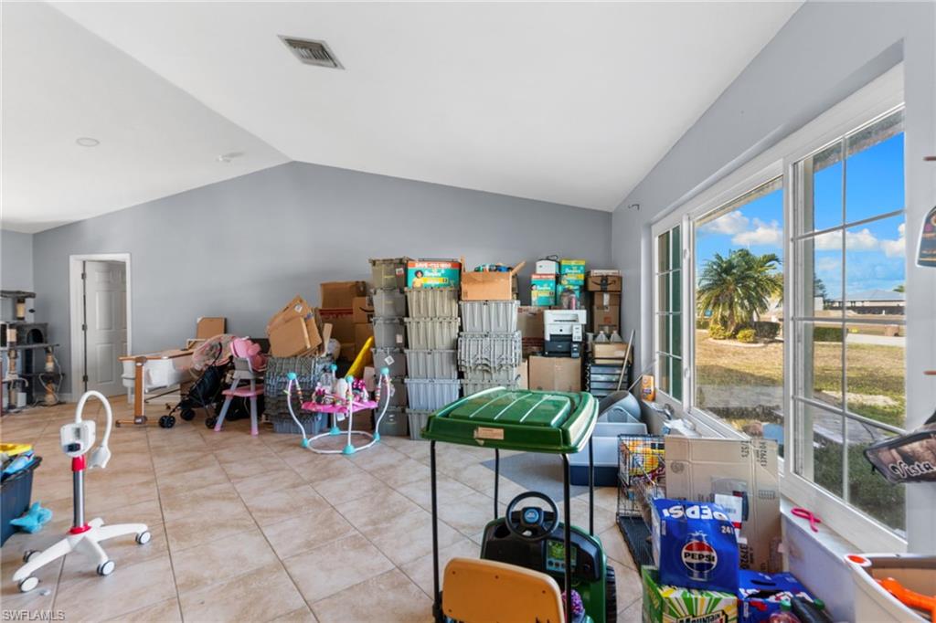 Game room with vaulted ceiling and tile patterned floors