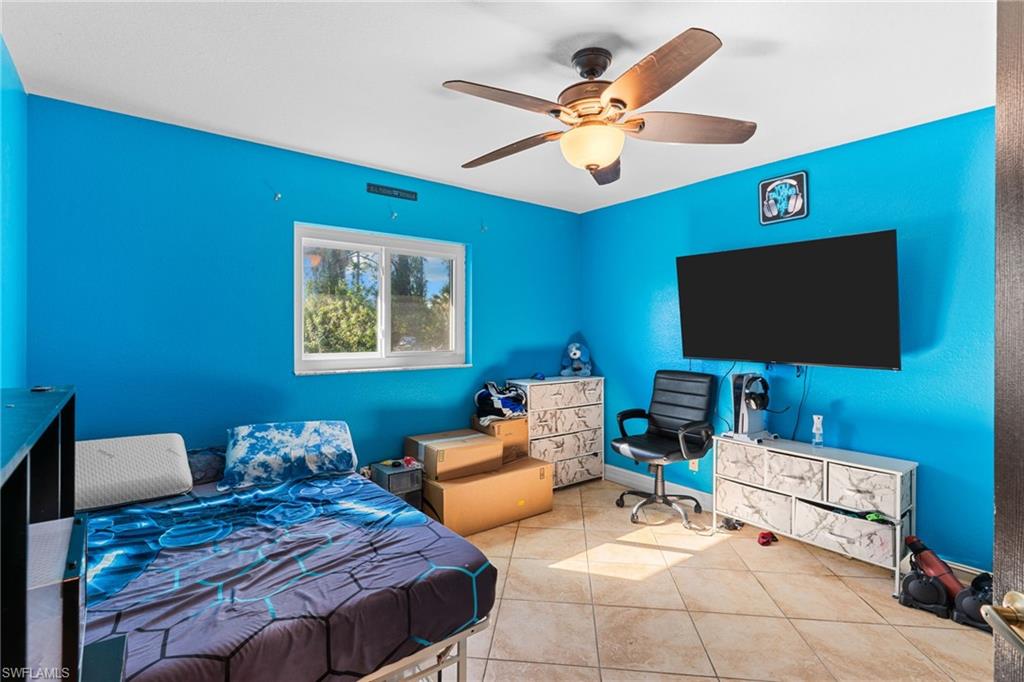Bedroom with ceiling fan and tile patterned floors