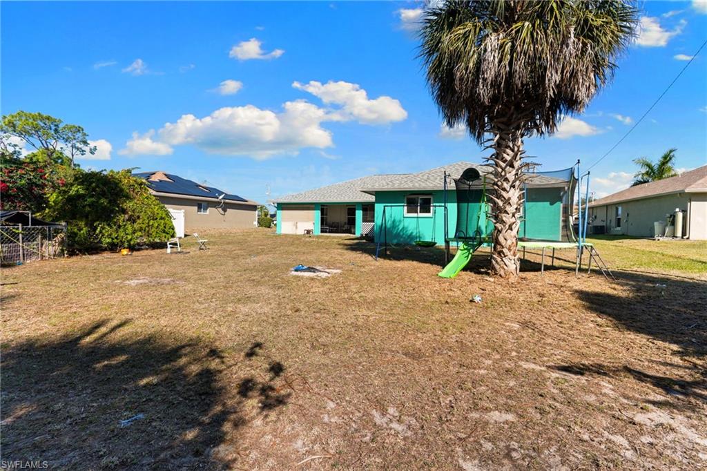 Rear view of house featuring a lawn and a playground