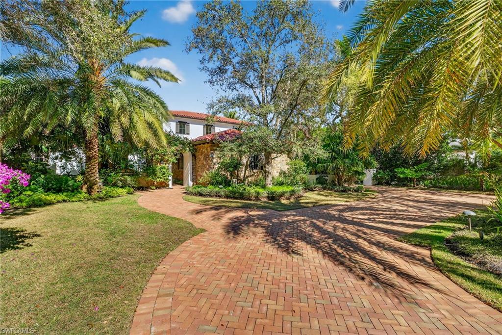 View of front of home with a front lawn and a tiled roof