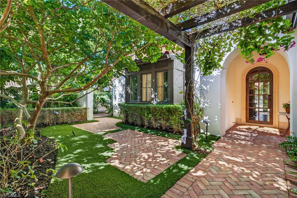 Entrance to property with stucco siding and a yard