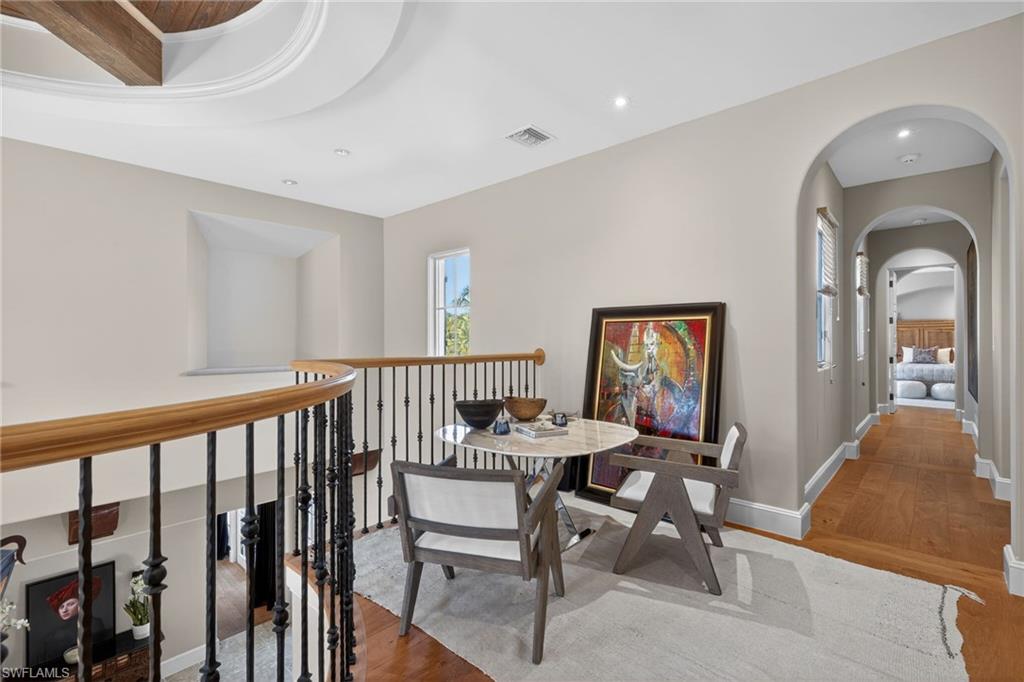 Hallway with wood finished floors and arched walkways