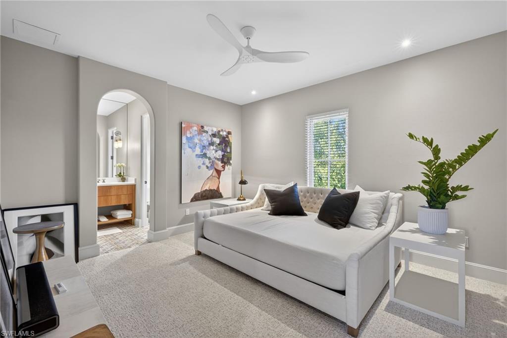 Bedroom with carpet, ceiling fan, arched walkways, recessed lighting, and ensuite bath