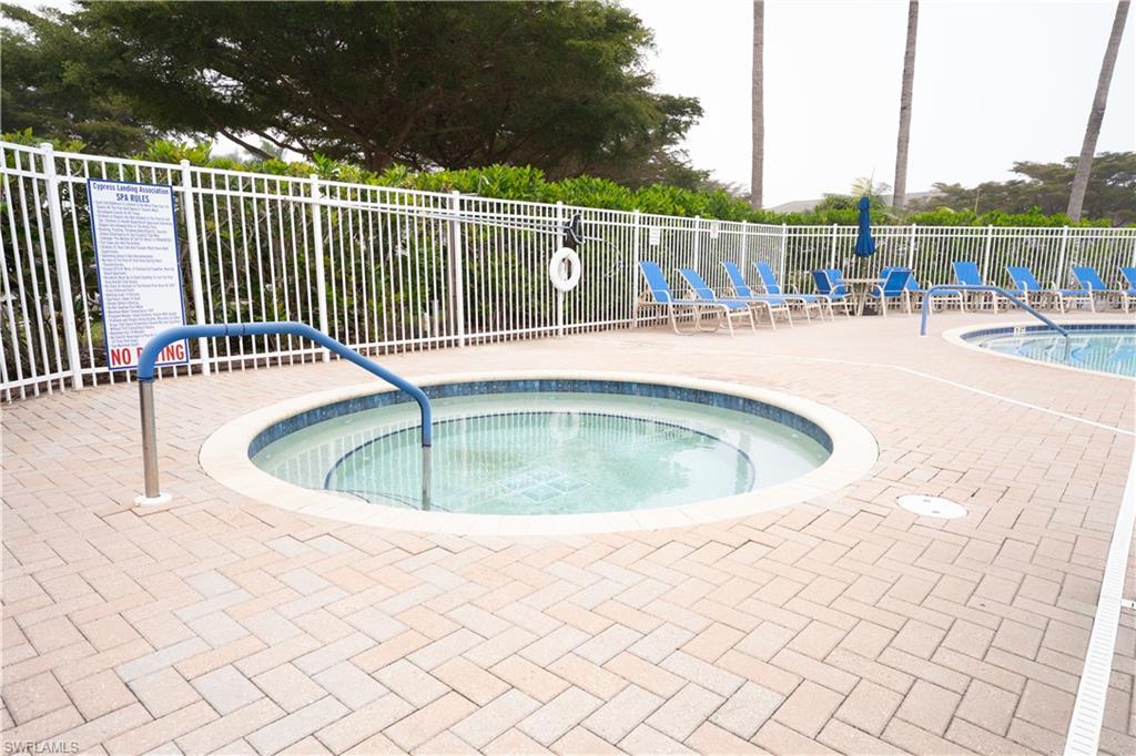 View of swimming pool with a hot tub, a swimming pool, and a patio area