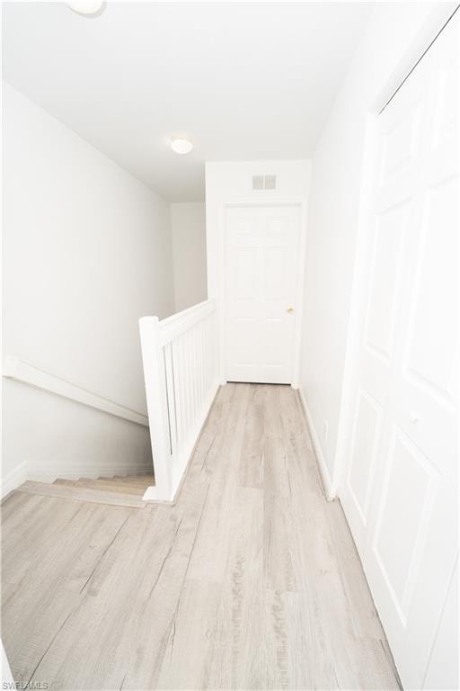 Corridor featuring light wood-style floors and an upstairs landing