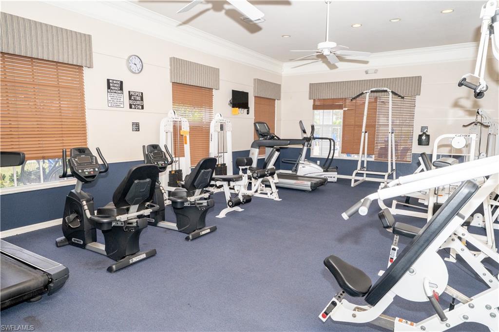 Gym with ornamental molding and a ceiling fan
