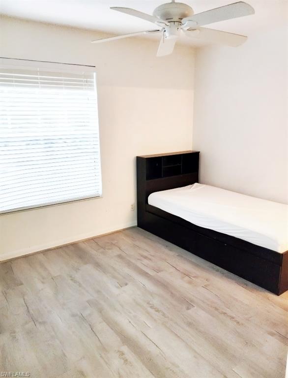 Unfurnished bedroom with ceiling fan and light wood-type flooring
