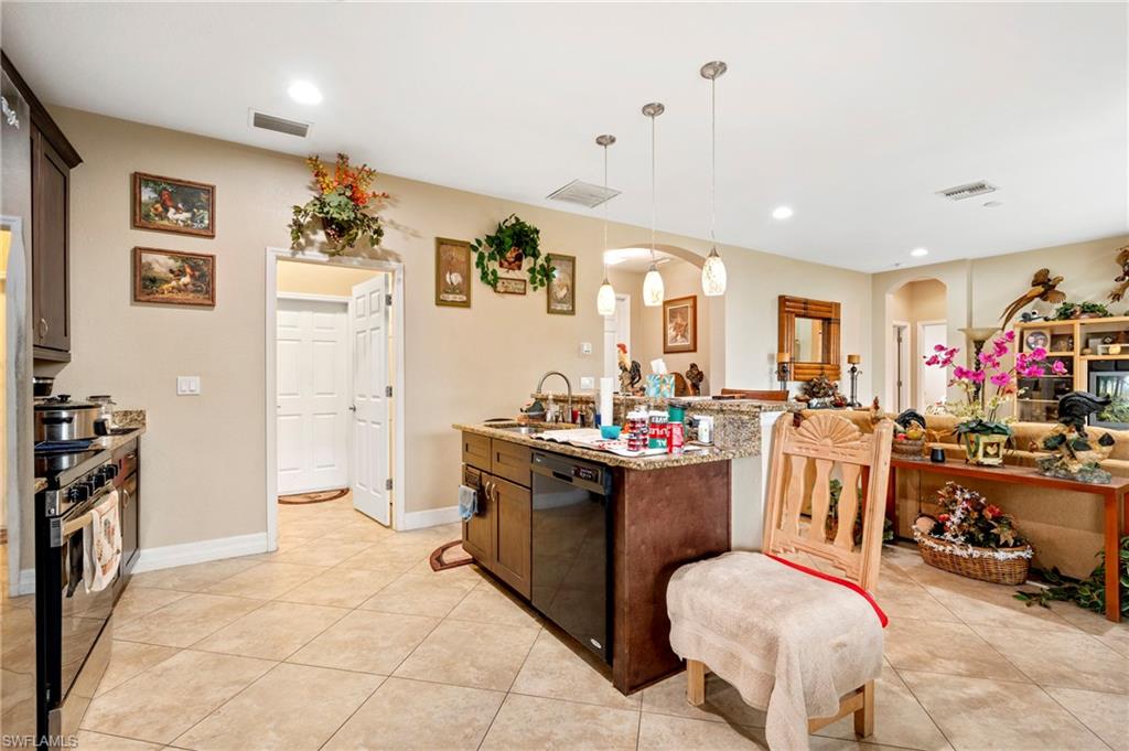 Kitchen with decorative light fixtures, light stone countertops, range with electric stovetop, dishwasher, and recessed lighting