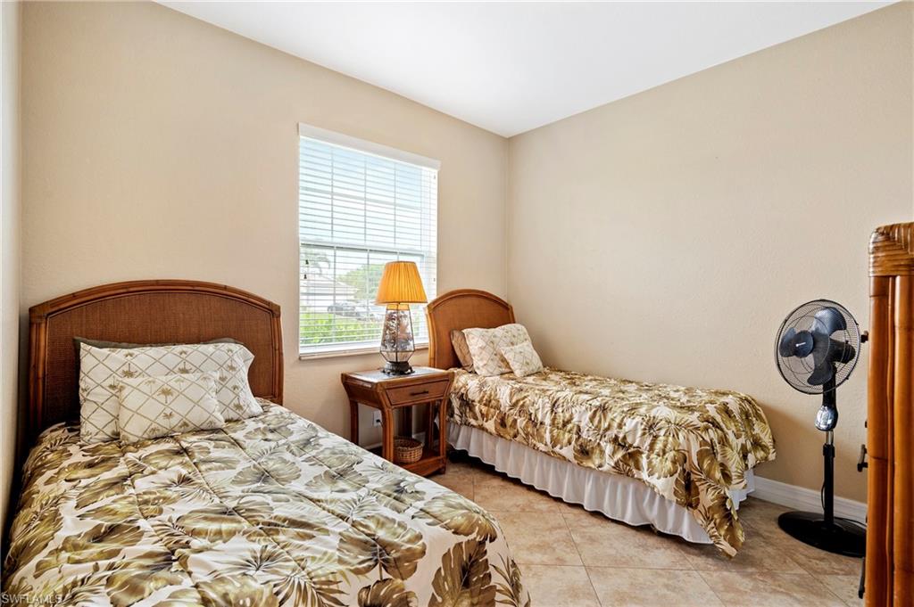 Bedroom featuring light tile patterned floors and baseboards