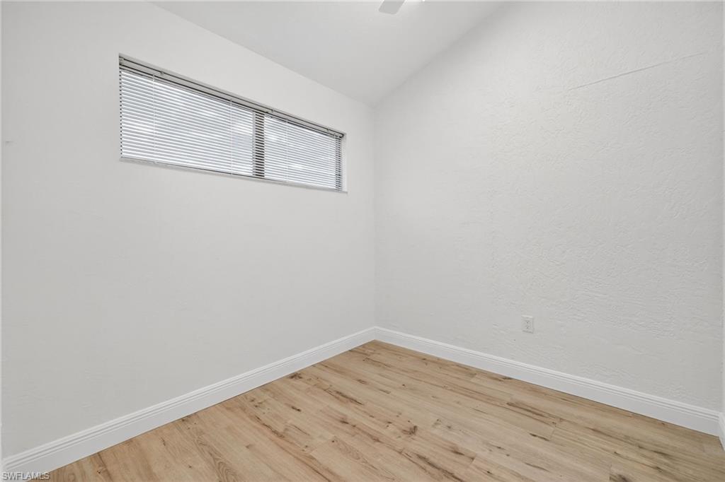 Spare room with lofted ceiling and light wood-style floors