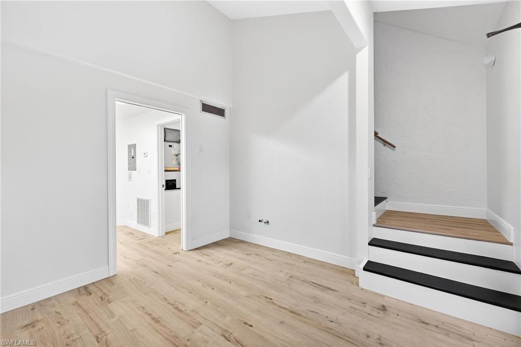 Staircase with wood finished floors and electric panel
