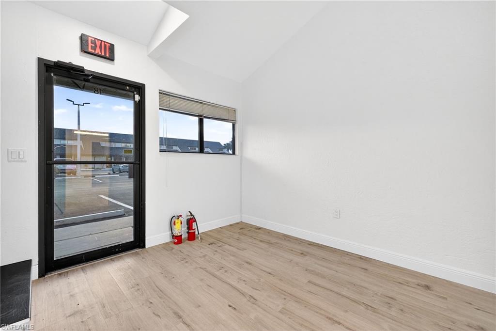 Empty room featuring vaulted ceiling and light wood-style flooring