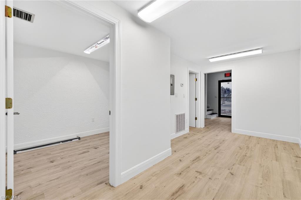 Corridor with light wood-style flooring and baseboards