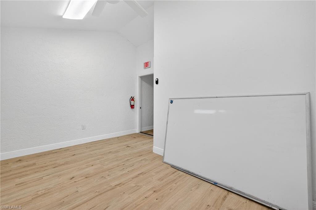 Spare room featuring lofted ceiling, a ceiling fan, and wood finished floors