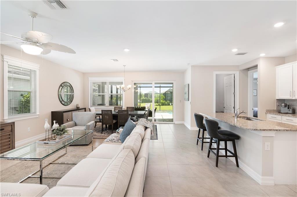 Living room featuring a chandelier, a ceiling fan, recessed lighting, and light tile patterned floors